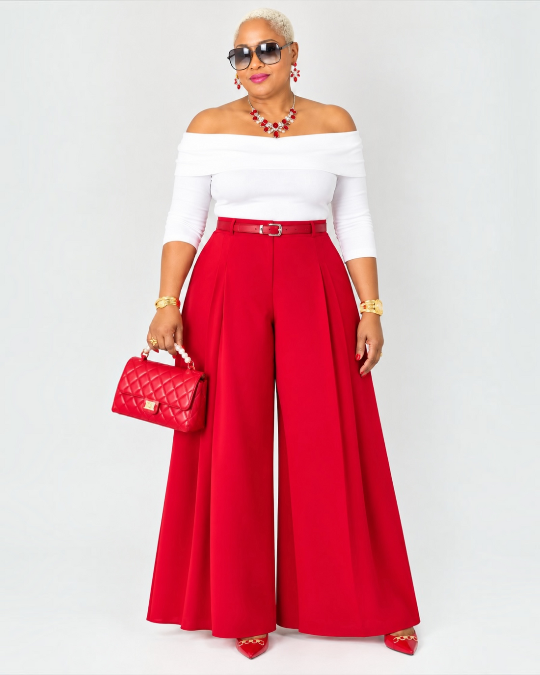 Deon wearing the red pleated wide leg pants with a white off the shoulder tope 
